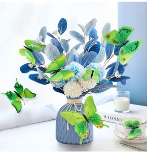 Detail of green 3D butterfly wall stickers within a floral arrangement in a blue vase