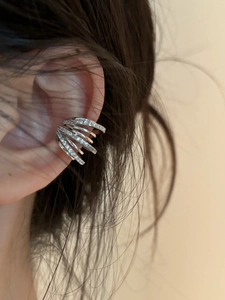 Close-up of a silver multi-layer ear cuff with zircons worn on the ear bone detail