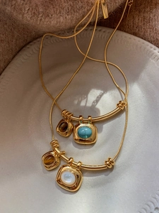Détail de colliers vintage plaqués or 18K avec pendentifs en turquoise et oeil de tigre