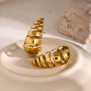 Macro shot of 18K gold plated stainless steel spiral drop earrings on a ceramic tray