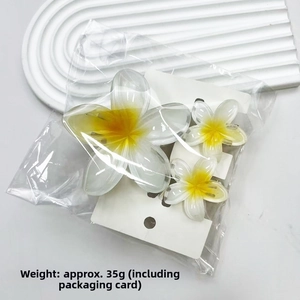 Detailed set of frangipani hair claws with yellow flower centers and marble texture finish