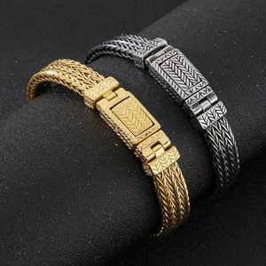 Close-up of punk style braided wheat pattern stainless steel bracelets in gold and silver