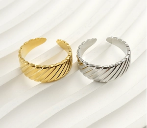 Detail of adjustable croissant rings in gold and silver finishes with striped texture