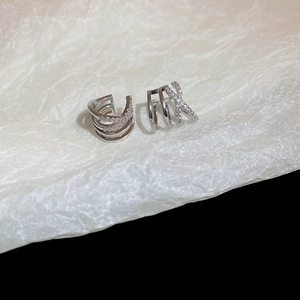 Macro shot of silver crisscross and layered ear cuffs with micro-pave cubic zirconia