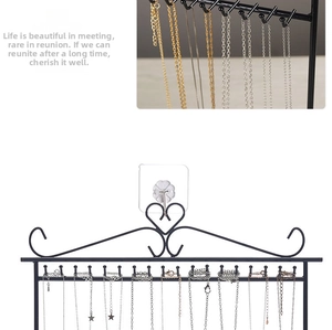 Wall-mounted iron jewelry organizer with heart scrollwork and multiple hooks for necklaces