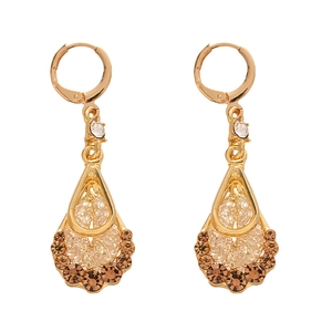 Vintage teardrop earrings with golden mesh structure and zircons on white background