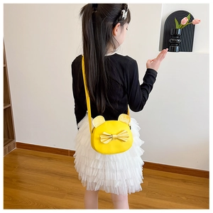 Detail of yellow kids crossbody bag with cute cat ears and golden sequin bow on a girl