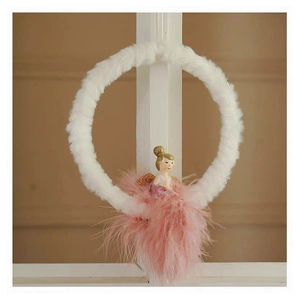Detail of plush white ring Christmas ornament with pink feather angel and golden wings