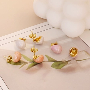 Detailed macro view of three pairs of droplet enamel stud earrings in soft pastel tones