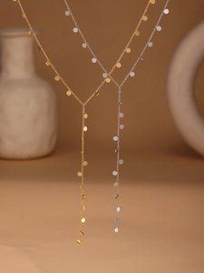 Detailed view of minimalist lariat tassel necklaces in 18k gold and silver finishes