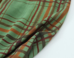 Close-up of classic plaid fabric texture in green and brown for women's blazer
