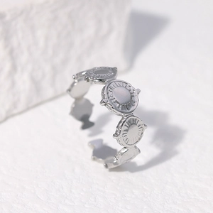 Detail of silver sunburst disc ring showing retro ethnic texture on stone background