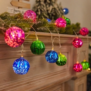 Luminous Christmas tree LED string lights with colorful faceted spheres on a mantelpiece