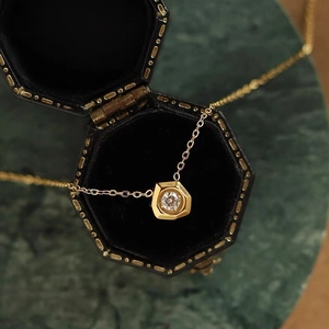 Collier en acier titane doré avec pendentif diamant géométrique hexagonal dans un écrin