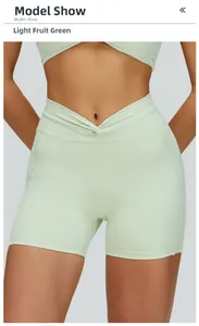 Dettaglio del design a V incrociato in vita sui pantaloncini da yoga verde chiaro