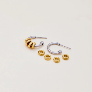 Macro shot of two-tone stainless steel C-shape earrings with detachable gold hoops