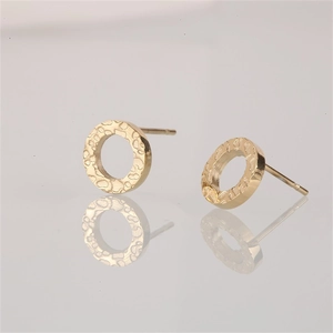 Detail of gold-plated geometric round stud earrings with unique hammered metal texture