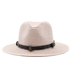 Detail of light beige straw hat featuring dark brown leather band with metal buckle
