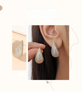 Close-up of golden teardrop stud earrings with pavé set sparkling crystals for women