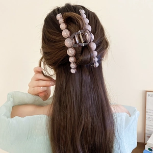 Elegant large resin hair claw clip with pink pearls shown on long hair hairstyle