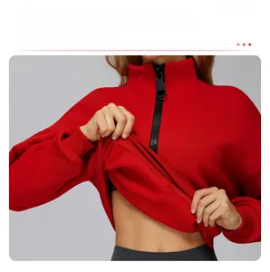 Detail of high ribbed cuffs and hem on red quarter-zip sweatshirt for wind protection