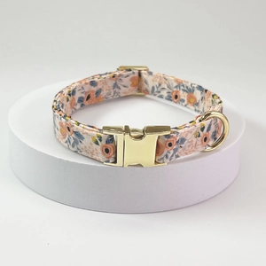 Detailed close-up of floral fabric pet collar with adjustable gold metal buckle and D-ring
