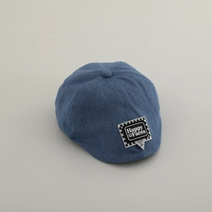 Vista macro della trama in denim blu e della toppa a scacchi sul berretto per bambini