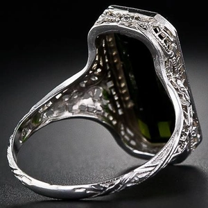 Vintage silver ring with large rectangular green gemstone and ornate carved details