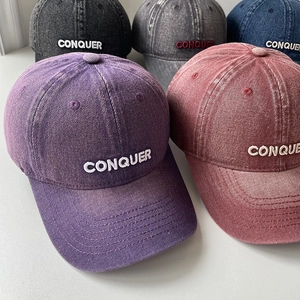 Detailed shot of various vintage washed baseball caps with CONQUER 3D embroidery