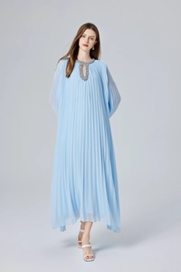 Détail d'une robe longue plissée bleu clair avec encolure ornée de perles à la main