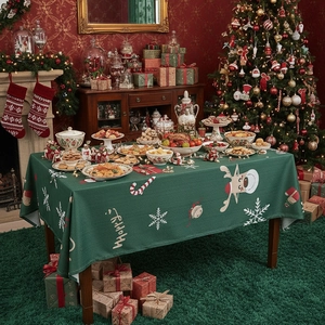 Festive Christmas tablecloth with reindeer and snowflake patterns on green fabric
