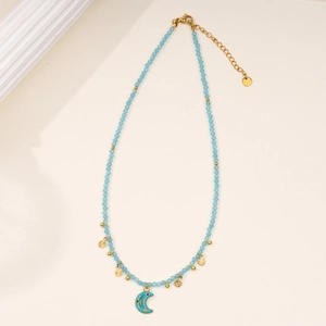 Close-up of sky blue beaded necklace with gold moon and star pendants and lobster clasp