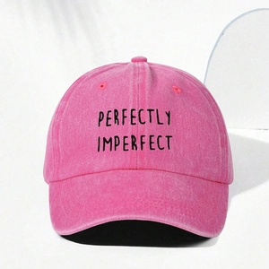 Macro shot of PERFECTLY IMPERFECT black embroidery on a pink washed cotton baseball cap