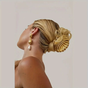 Golden seashell hair claw and pearl earrings set shown on a model for a beach summer style