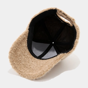 Detail of warm beige faux shearling baseball cap with durable black inner lining
