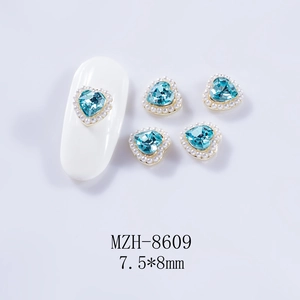 Vue macro de bijoux d'ongles cœur bleu 7,5x8mm avec bordure perle et base dorée