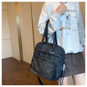 Model wearing a black canvas ita bag with a clear window and adjustable shoulder strap