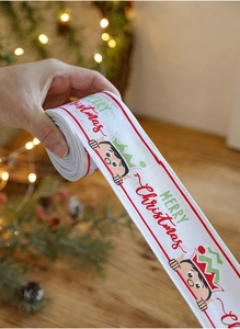 Detail of Christmas ribbon with cartoon elves and Merry Christmas print for gift wrapping