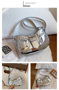Detail view of silver metallic motorcycle bag with studs, buckles and zipper pockets