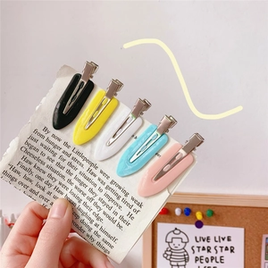 Macro detail of seamless hair clips in five pastel colors with metal duckbill closure
