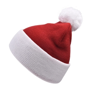 Detail of red and white knitted Christmas hat showing texture and white pompom on top