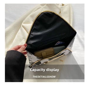 Detail view showing interior capacity of black and white cow print envelope clutch bag