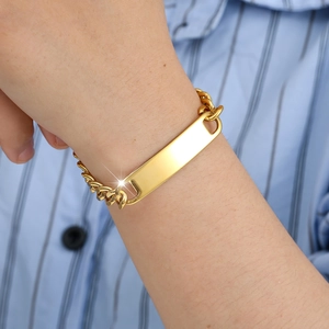 Close-up of golden stainless steel Cuban link bracelet with a blank bar on wrist