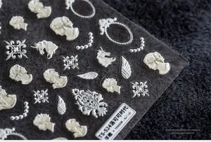 Primo piano di adesivi 3D per unghie Rococò con ritratti vintage e motivi di perle