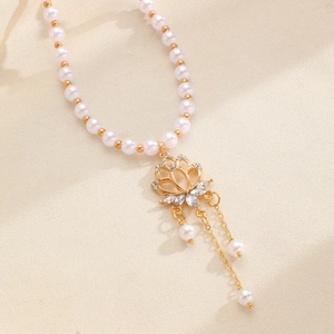 Detailed view of retro beaded pearl necklace with exquisite golden lotus flower rhinestone pendant.