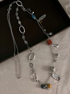 Detailed close-up of retro bohemian necklace with ceramic beads and leaf metal charms