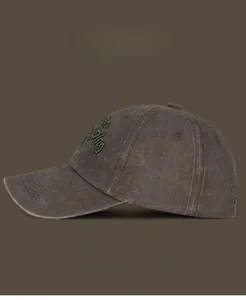 Detailed close-up of dark coffee vintage washed cotton baseball cap with green embroidery