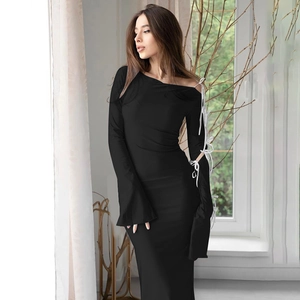Detail of elegant black off-shoulder dress with white lace-up sleeve and flared cuffs