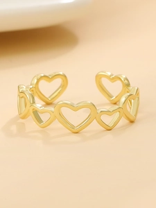 Dettaglio di un anello regolabile dorato con una serie di motivi a forma di cuore
