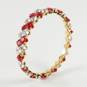Detail of gold-plated bangle with square-cut red and clear crystals in 45-degree angle